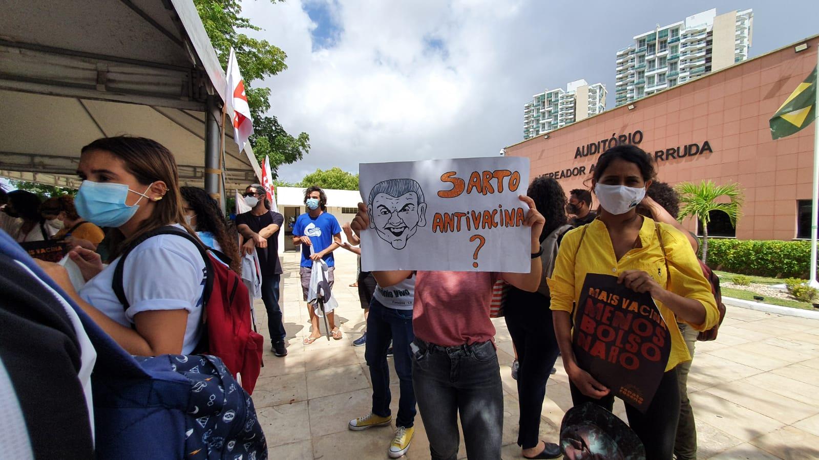 Manifestantes com cartaz em prol do passaporte