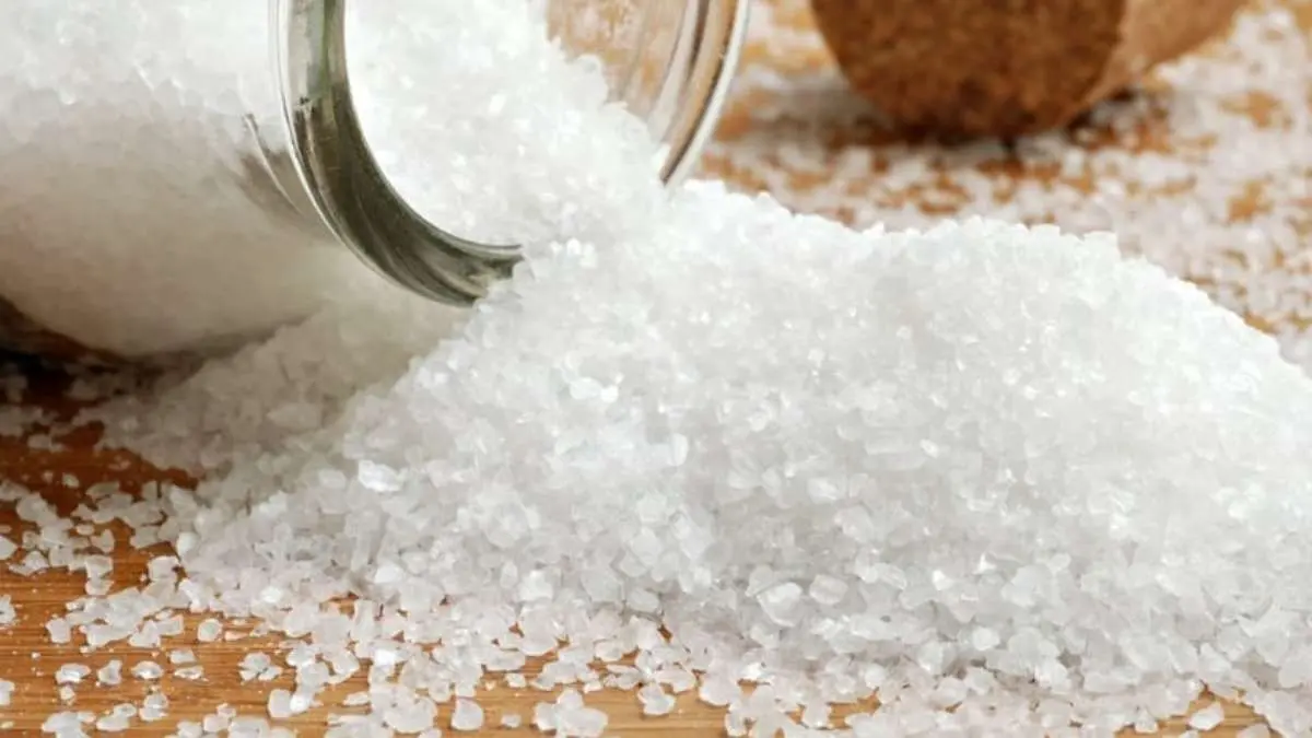 Sal grosso derramado de um pote de vidro