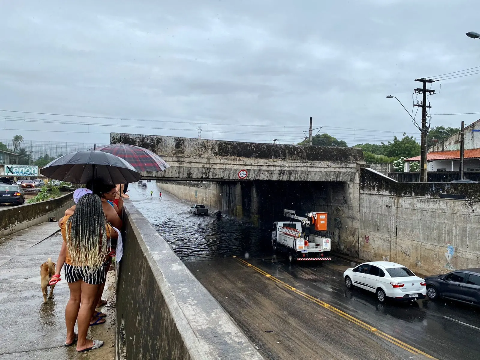 Pessoas observam chuvas e alagamento
