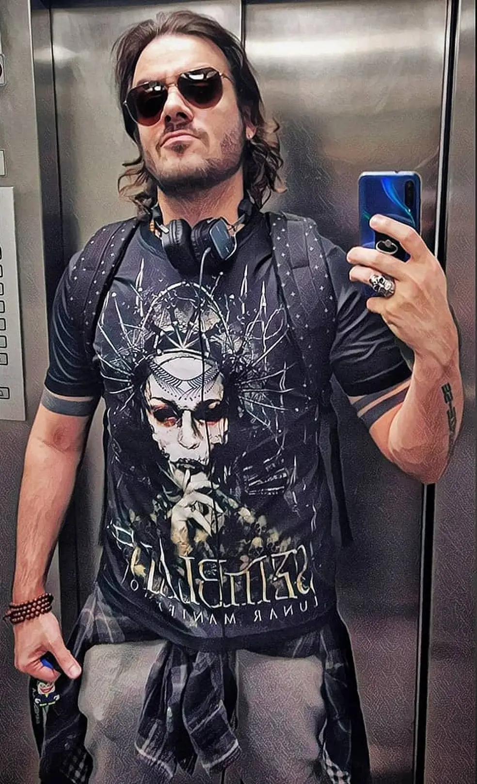 max porto com óculos e celular na mão