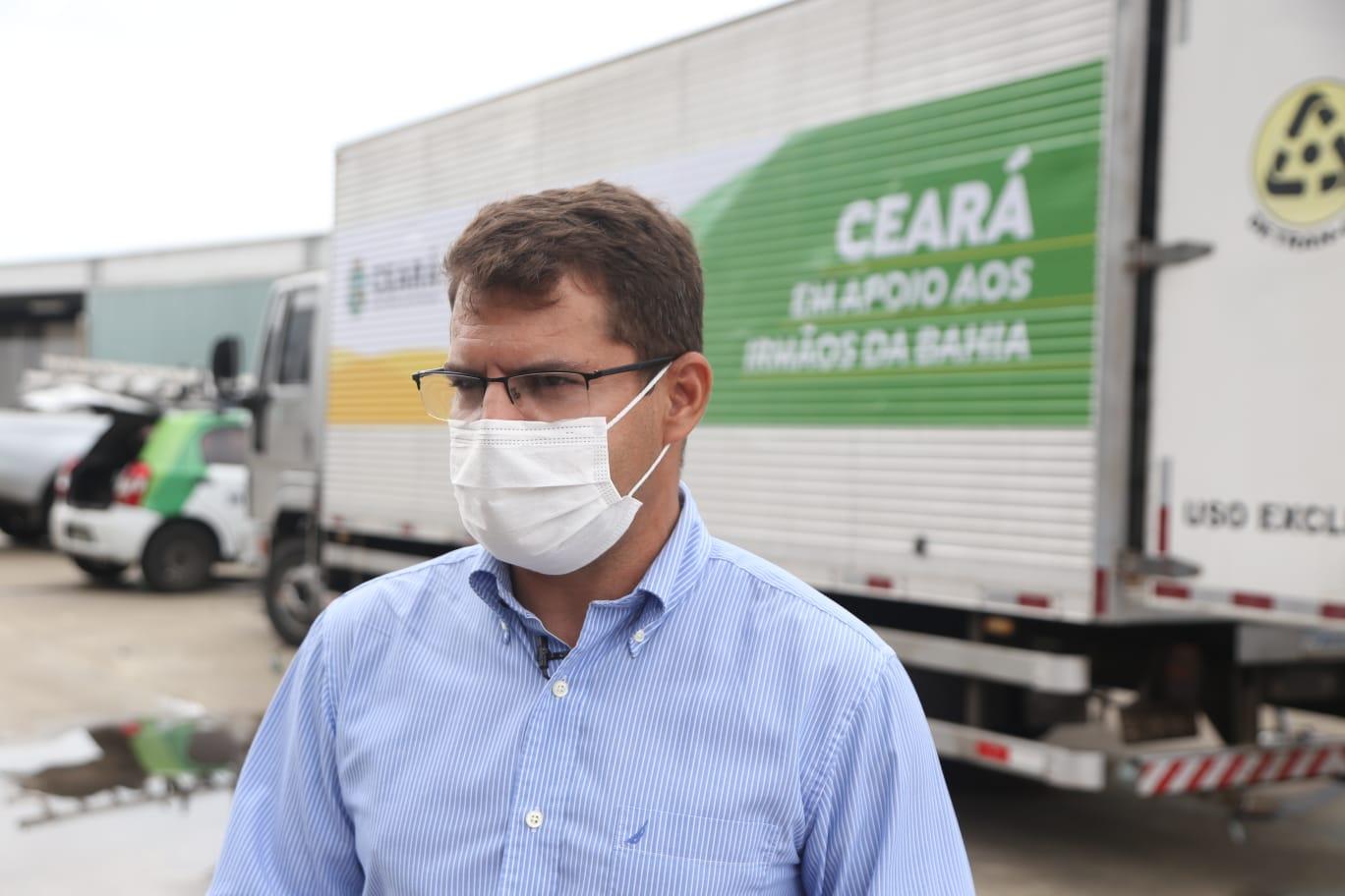 Rogério Pinheiro posa para foto na frente de caminhão de doação