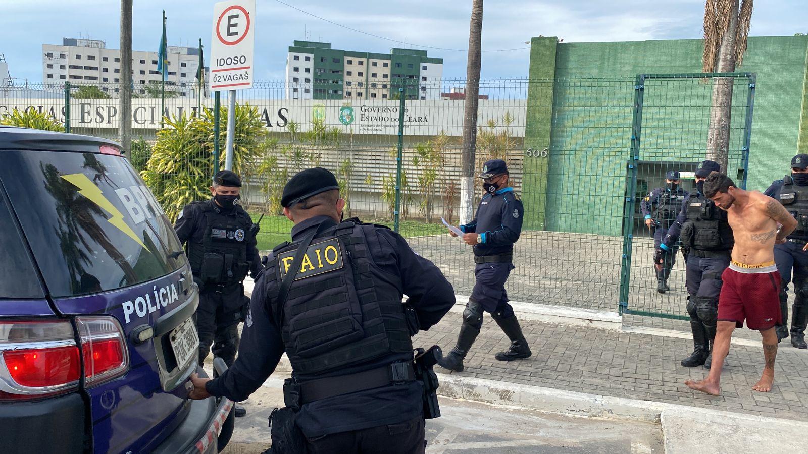 Suspeito preso em cativeiro na Messejana sendo conduzido para viaturas por diversos policiais