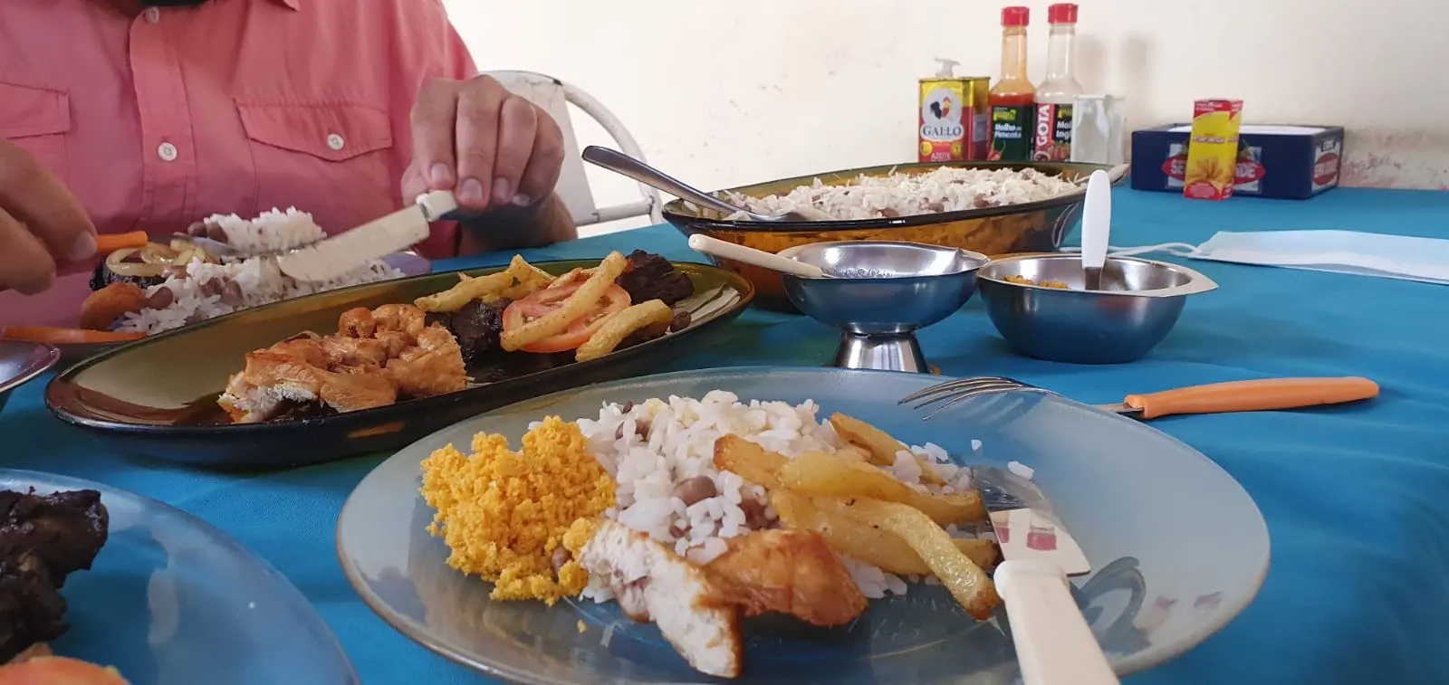Foto do prato pedido no restaurante: baião de dois coberto com queijo ralado, carne de sol, tomate em rodela, cebola refogada e um macarrão