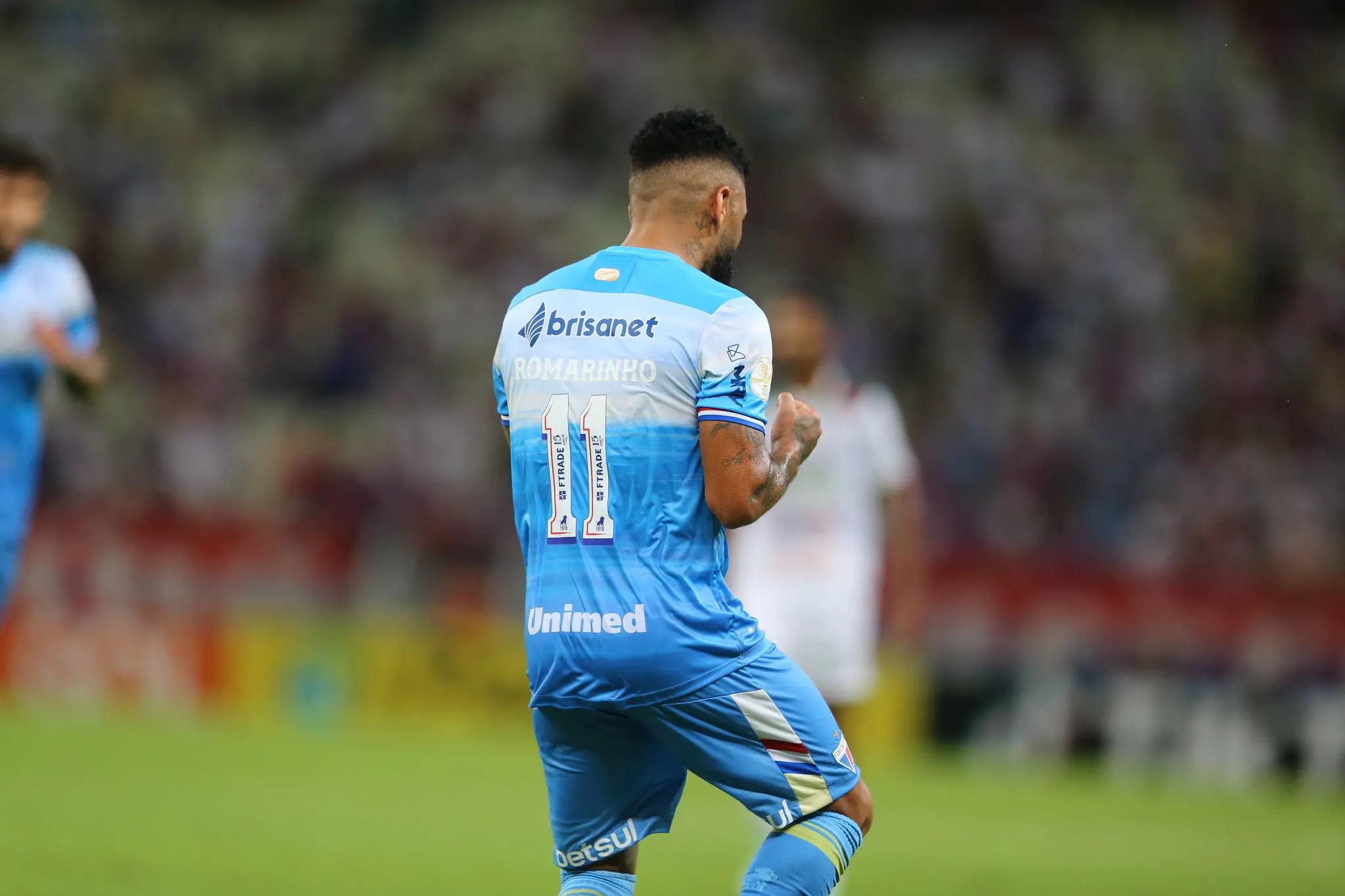 Romarinho de costas comemorando gol marcado