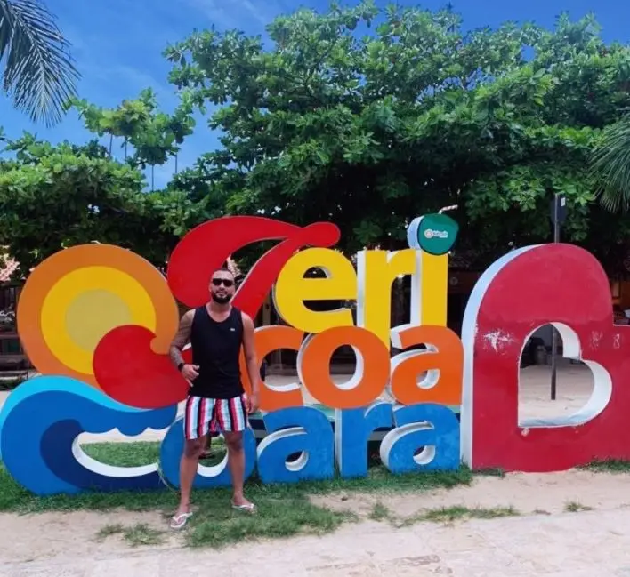 turista de são paulo diante de placa com o nome de jericoacoara