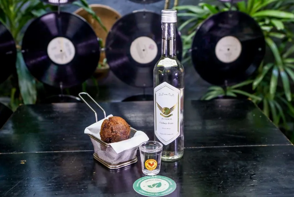 A Rota Alucinação é composto por uma dose de cachaça Aviador + 2 bolinhos de feijoada