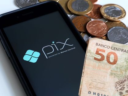 tela de celular com o nome pix ao lado de notas de dinheiro e moedas