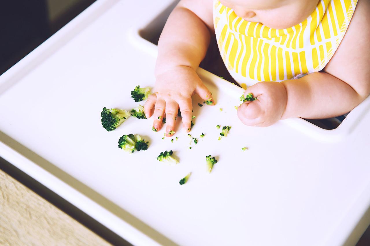 Criança comendo brócolis