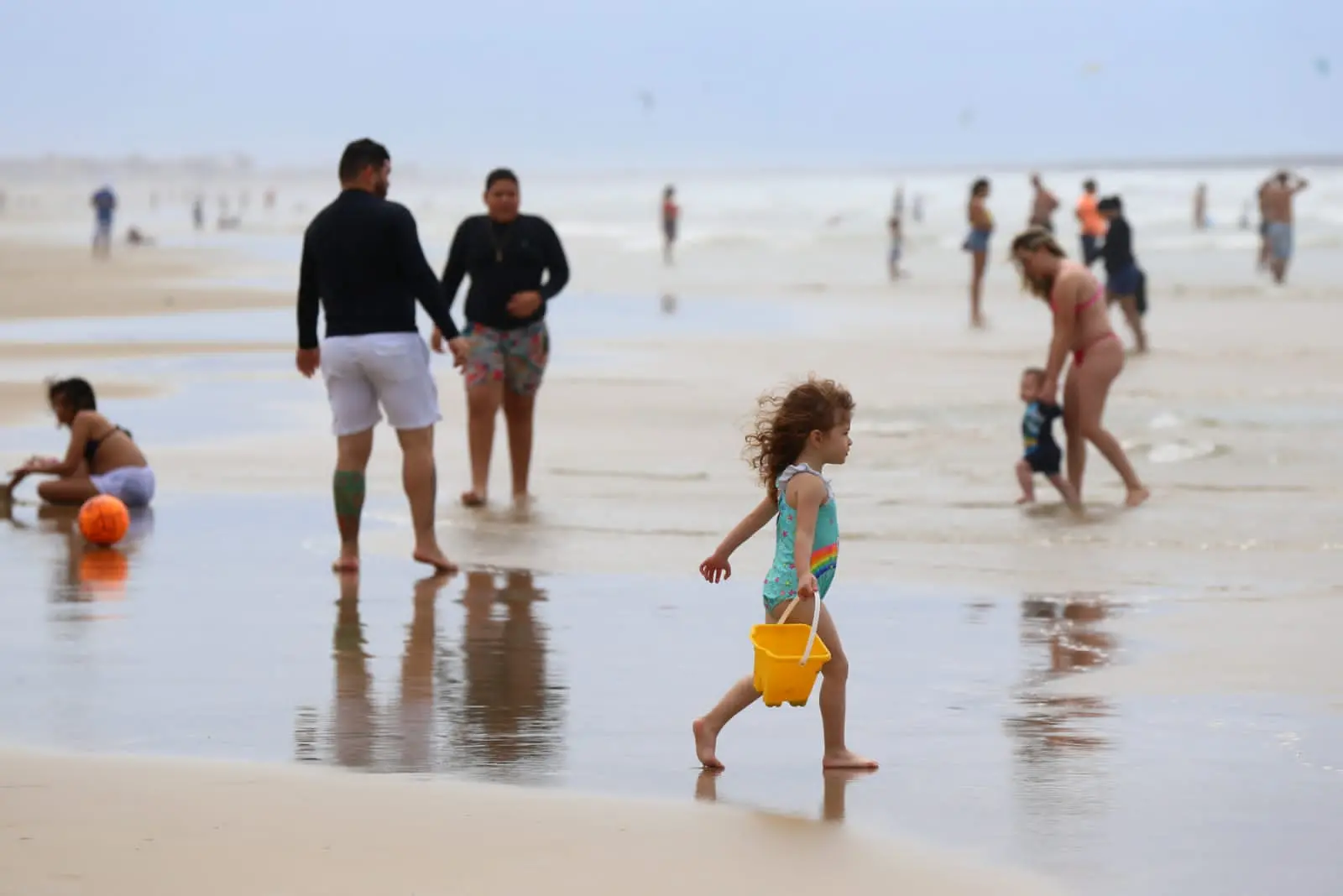 Criança brinca do balde na areia