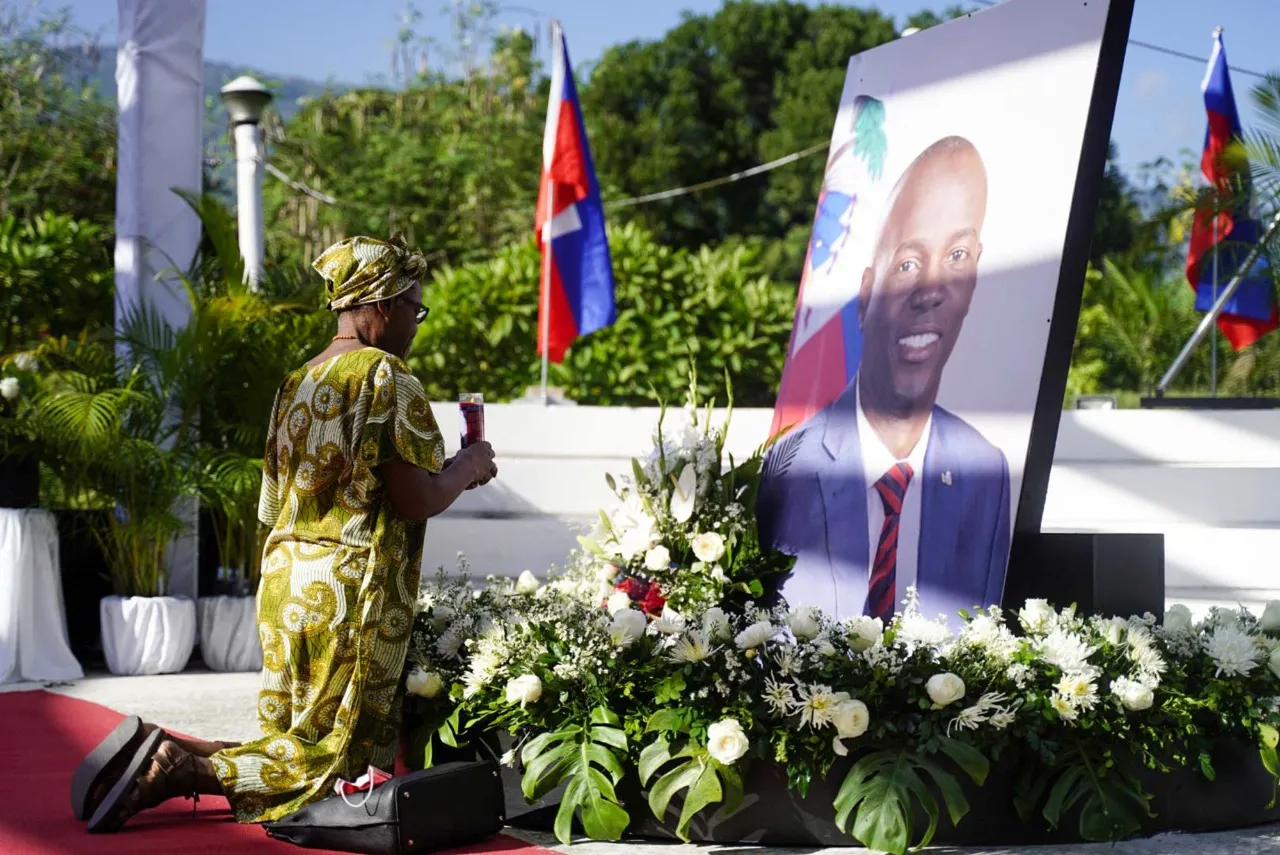 Uma apoiadora do presidente haitiano reza em um memorial que marca o primeiro aniversário do assassinato de Jovenel Moïse