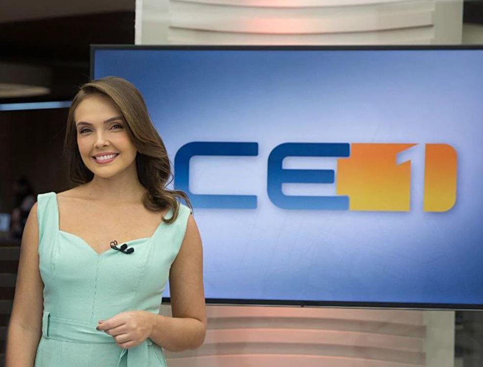 taís lopes diante de televisão com a marca de1