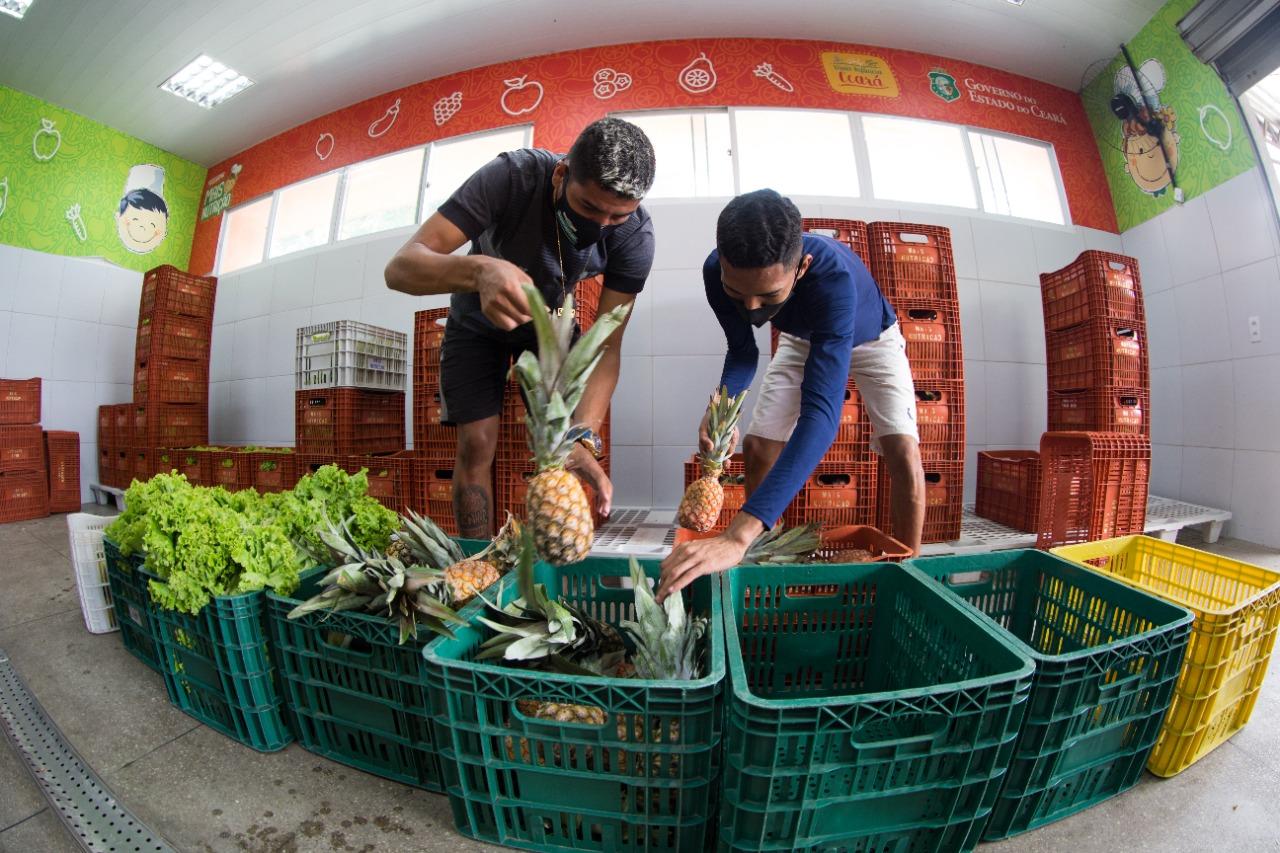 Homens separando alimentos/ abacaxi e alface