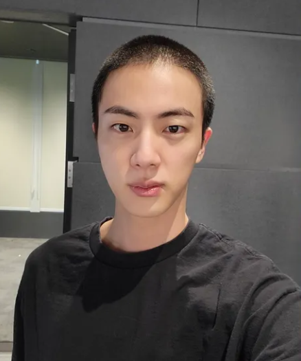 Jin com cabelo raspado