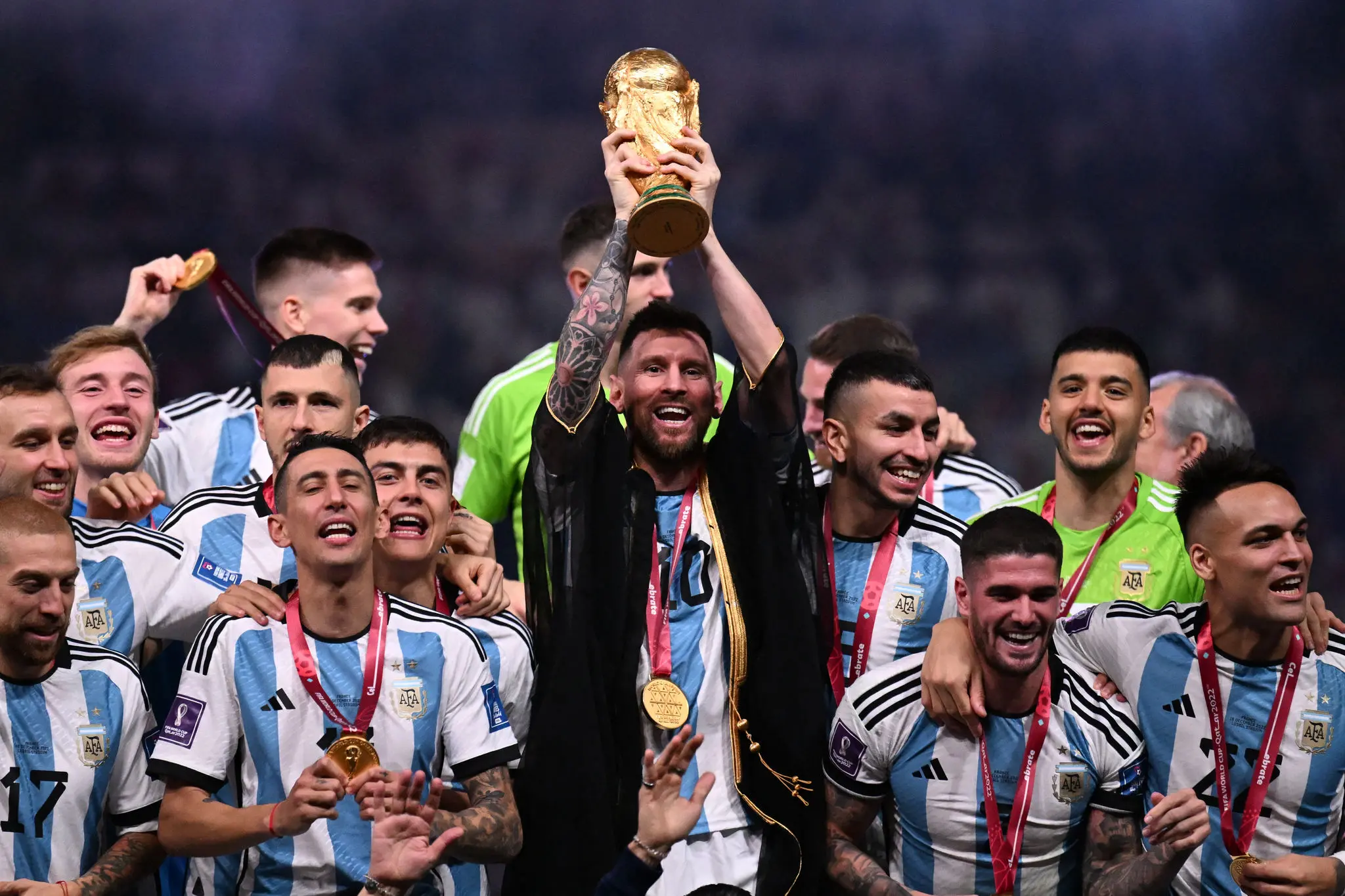 Imagem de Messi, ao lado de seus companheiros de equipe, erguendo a taça da Copa do Mundo