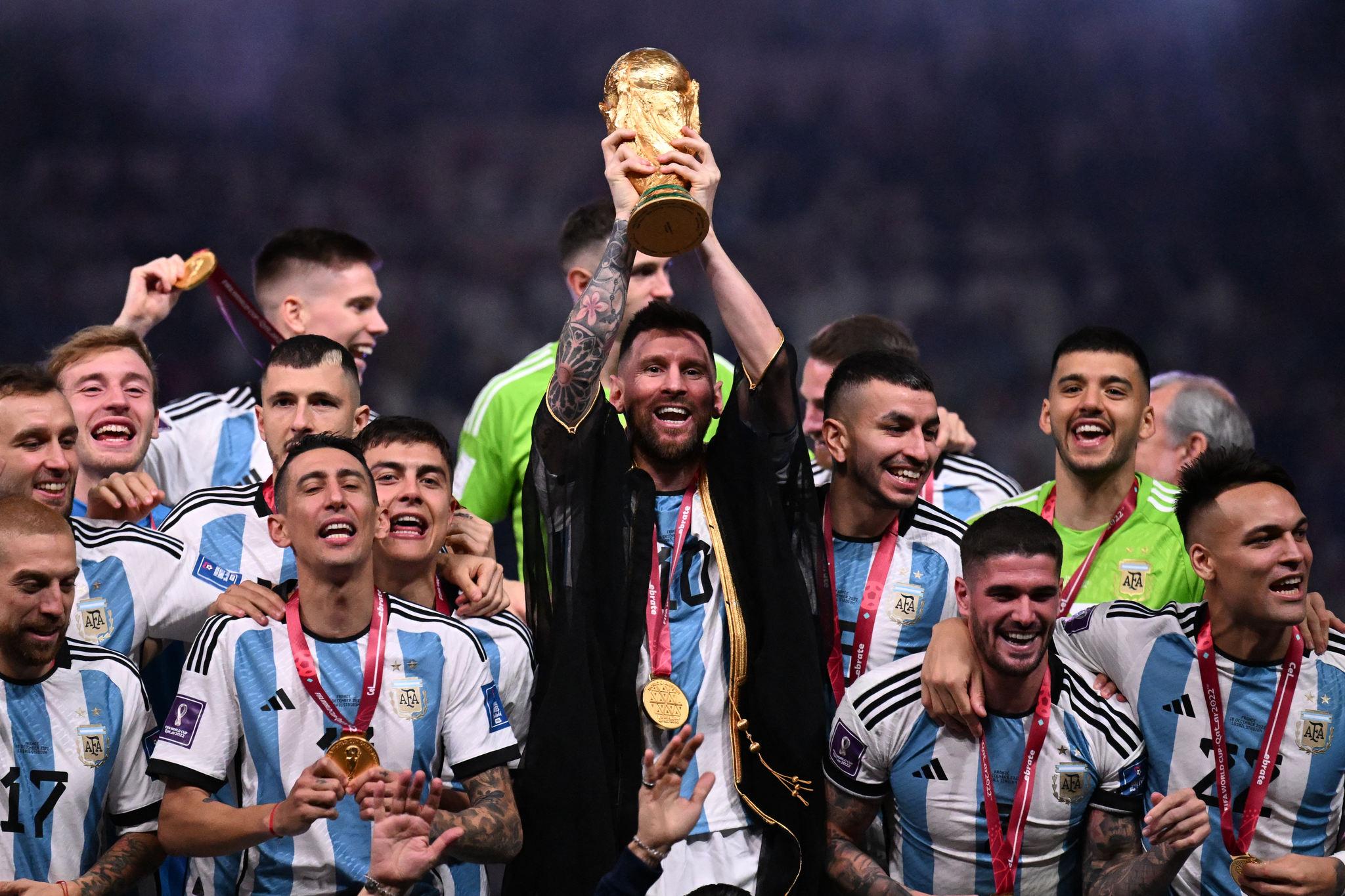 Imagem de Messi, ao lado de seus companheiros de equipe, erguendo a taça da Copa do Mundo