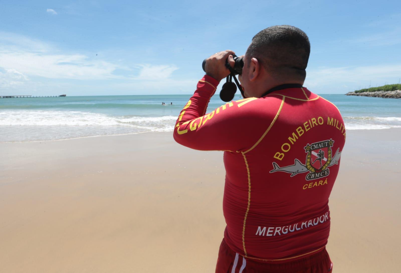 mergulhador usa binóculo e mira em direção ao mar