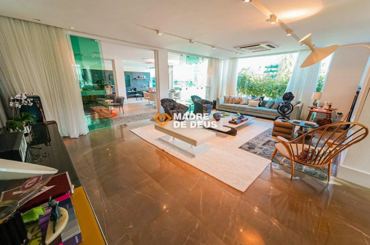 A casa possui 500 m², tem portas blindadas, 4 suítes (suíte master com 80m²), escritório, jardim, garagem para 6 carros