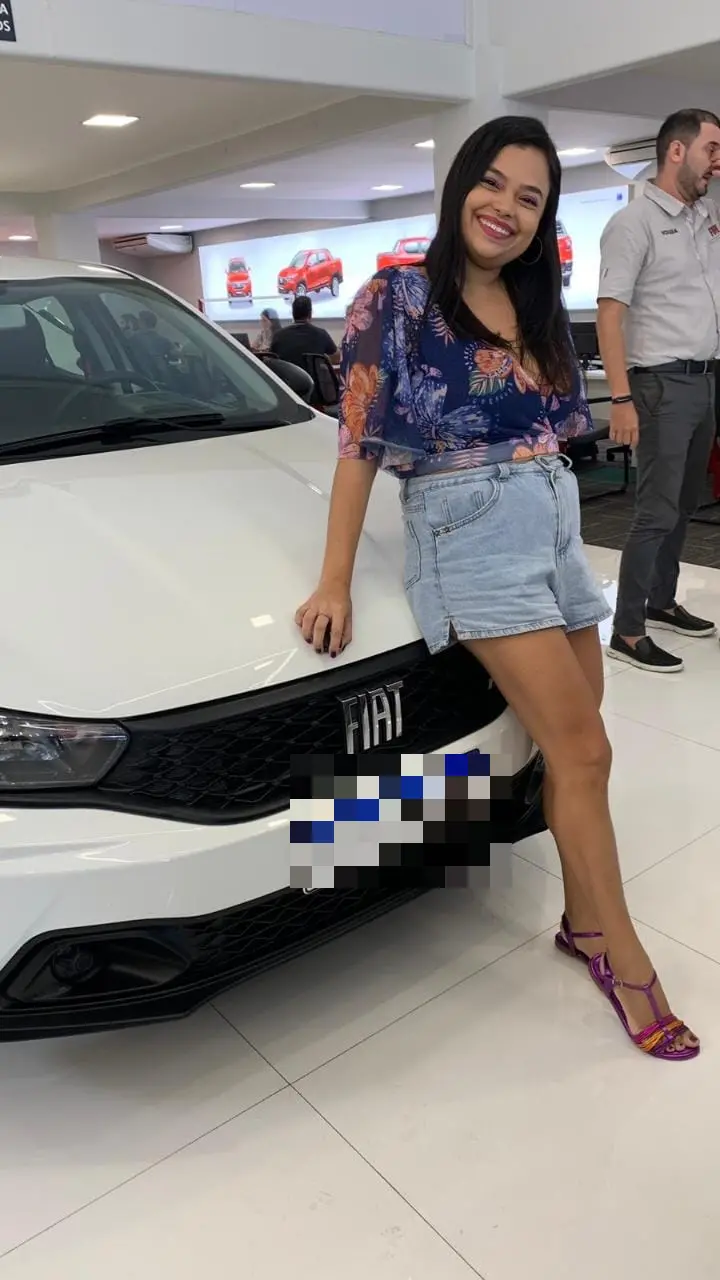 Publicitária Vanêssa sentada em seu carro novo da Fiat