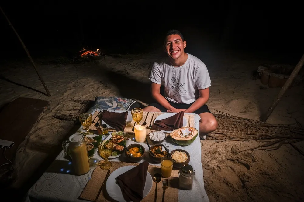 Perto da mesa do jantar, uma fogueira é acesa, velas são postas entre as peças do jogo americano, e está formado o clima ideal sob a luz da lua