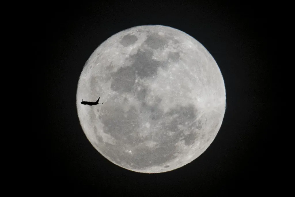 Superlua aparecendo atrás de um avião de passageiros no Rio de Janeiro