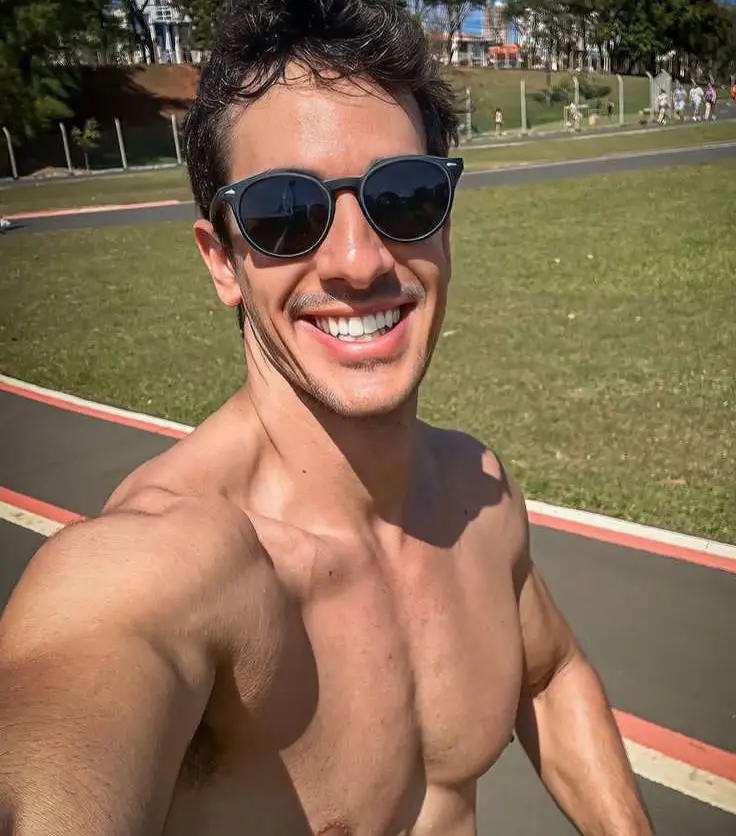 Henrique é um homem branco e na foto está sem camisa e de óculos escuros