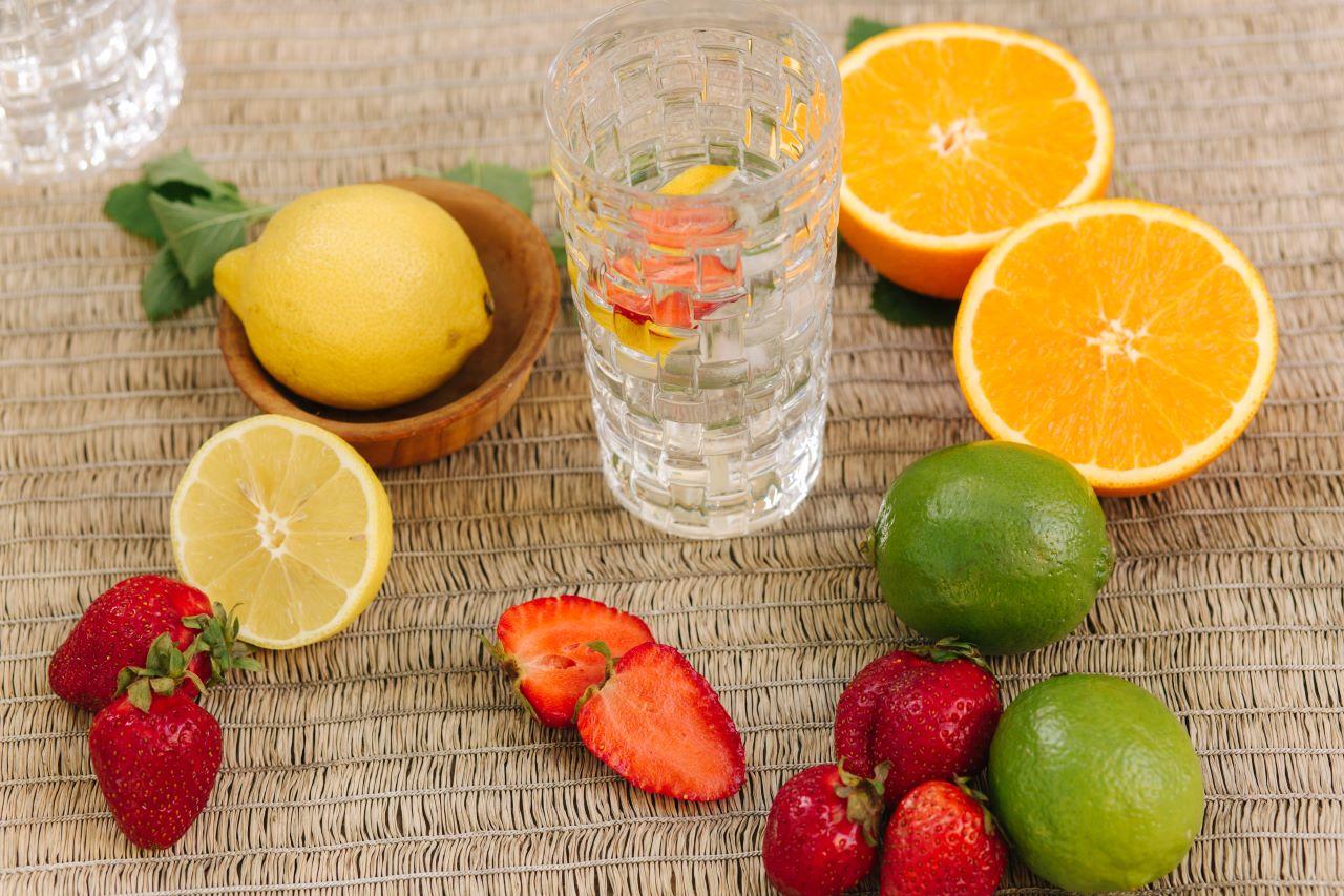 copo d'água e frutas ao redor