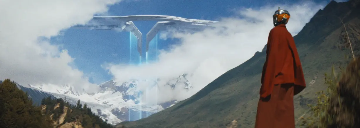 No meio de colinas, um robô vestido com capa vermelha, observa nave espacial