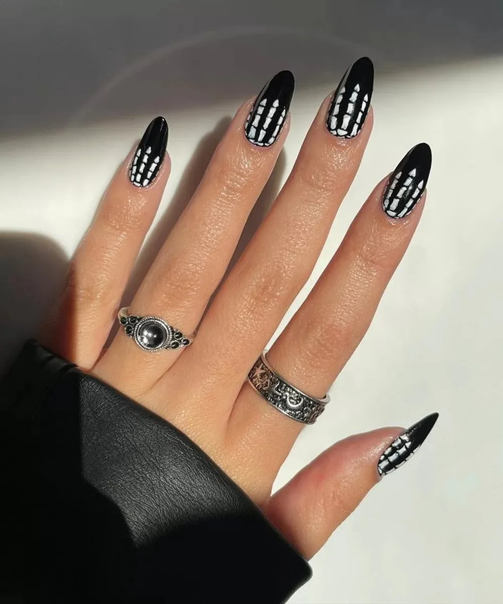 Os clássicos esqueletos são uma opção para as unhas de Halloween