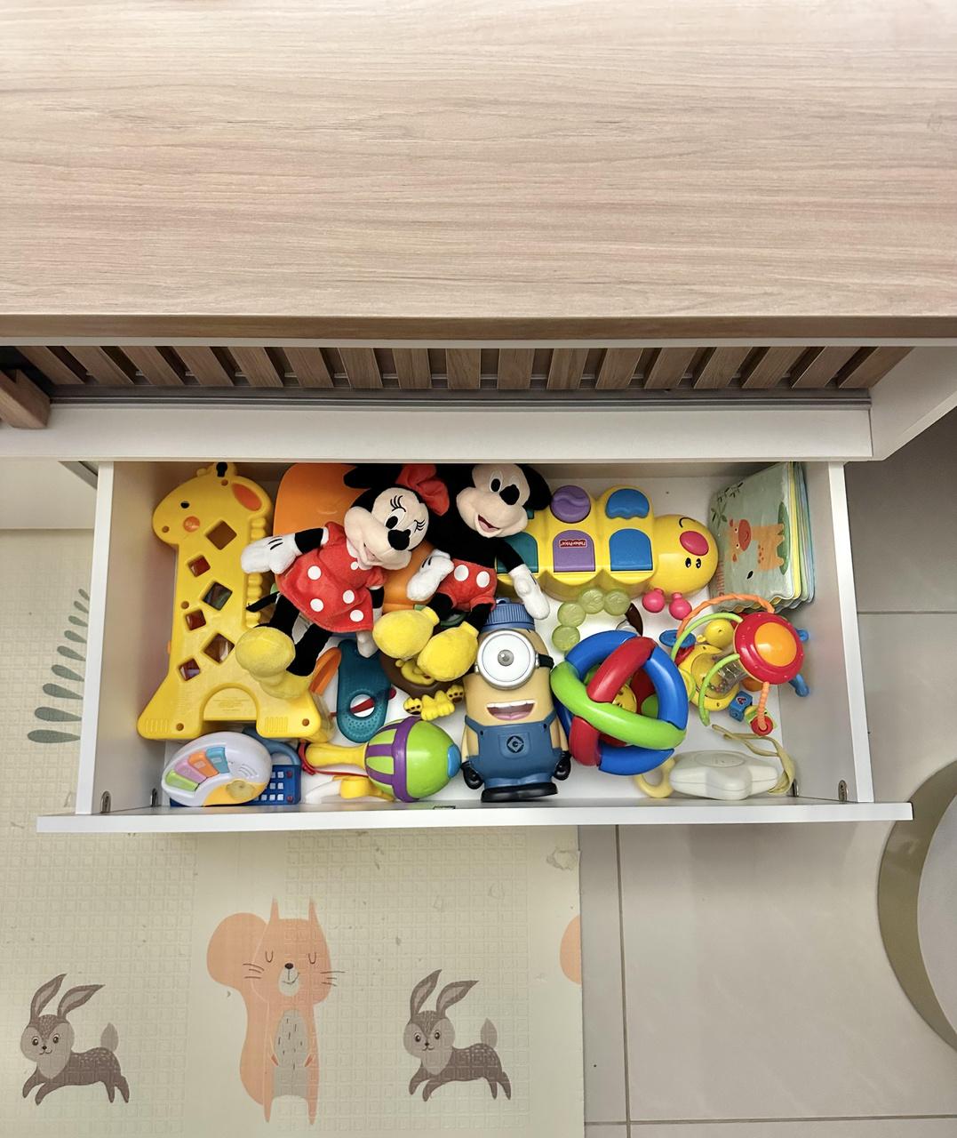 Gaveta no rack de tv armazena brinquedos e ajuda a manter organização