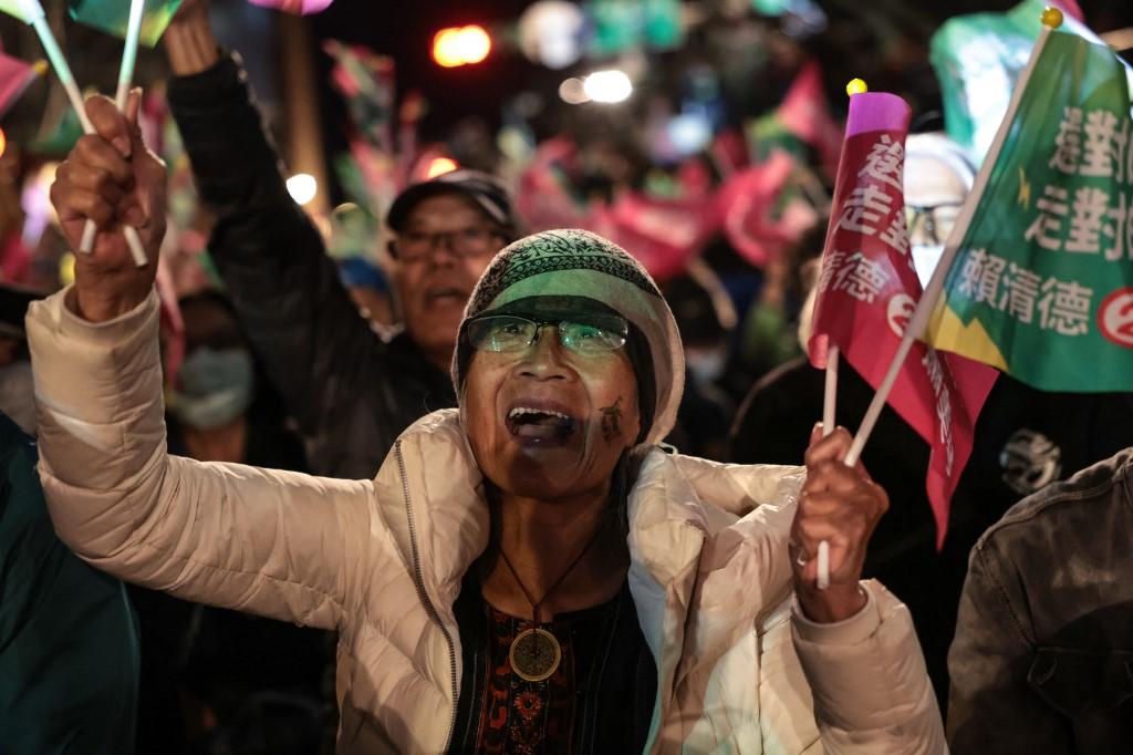 Apoiadora do vice-presidente de Taiwan e candidato presidencial Lai Ching-te agita bandeiras enquanto espera pelos resultados da eleição presidencial