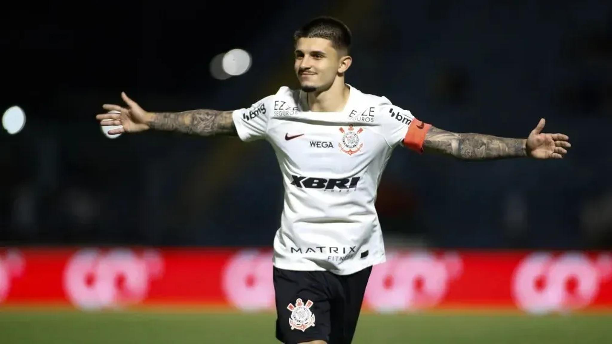 Jogador do Corinthians de braços abertos, comemorando