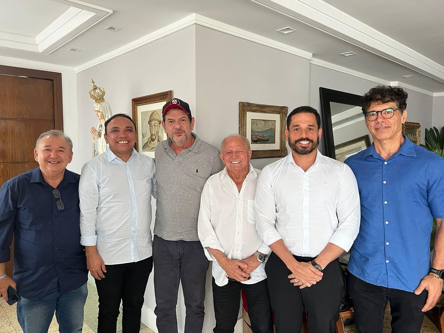A imagem mostra os pré-candidatos de oposição em Aquiraz e em Eusébio, Jair Silva (PP) e Edson Sá (PSB) posando ao lado de aliados para o pleito municipal. O senador Cid Gomes é um dos presentes.