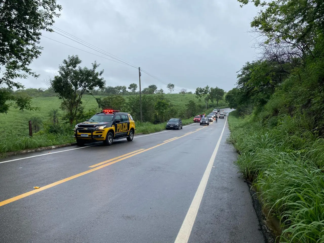 Imagem mostra viatura da POlícia Militar atuando em acidente na CE-060, registrado em 4 de março de 2024. Van com 11 passageiros derrapa e cai em ribanceira na região do Cariri