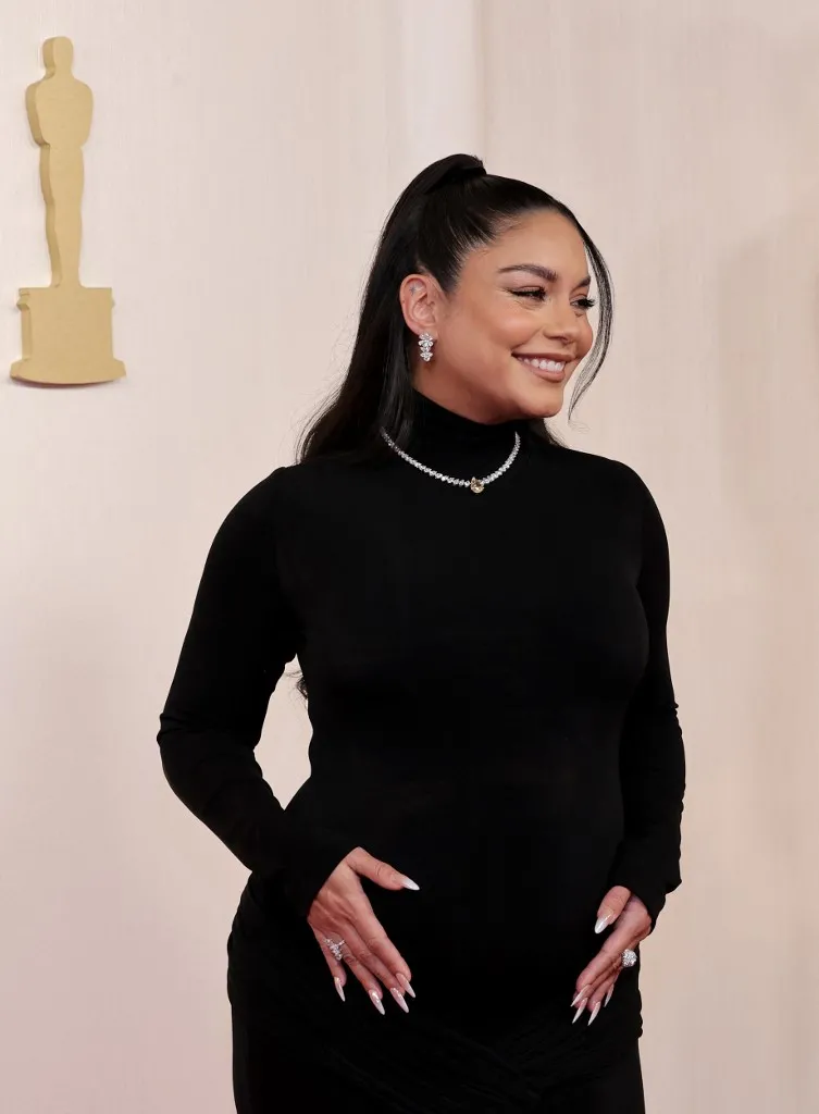 A atriz usa um vestido preto e colado para realizar o anúncio