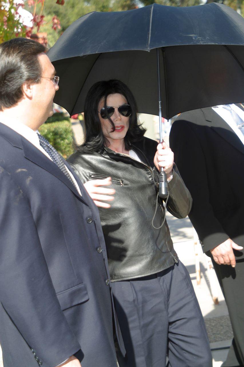 michael jackson com guarda-chuva, óculos escuros andando na rua