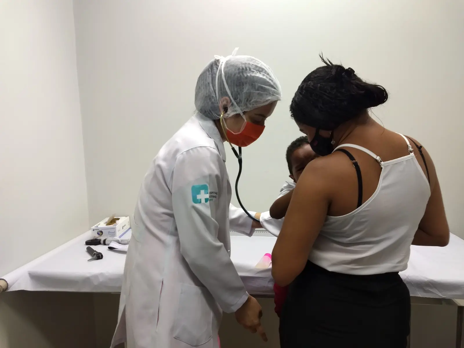 mãe segura filho no colo durante consulta no Hospital Regional Norte