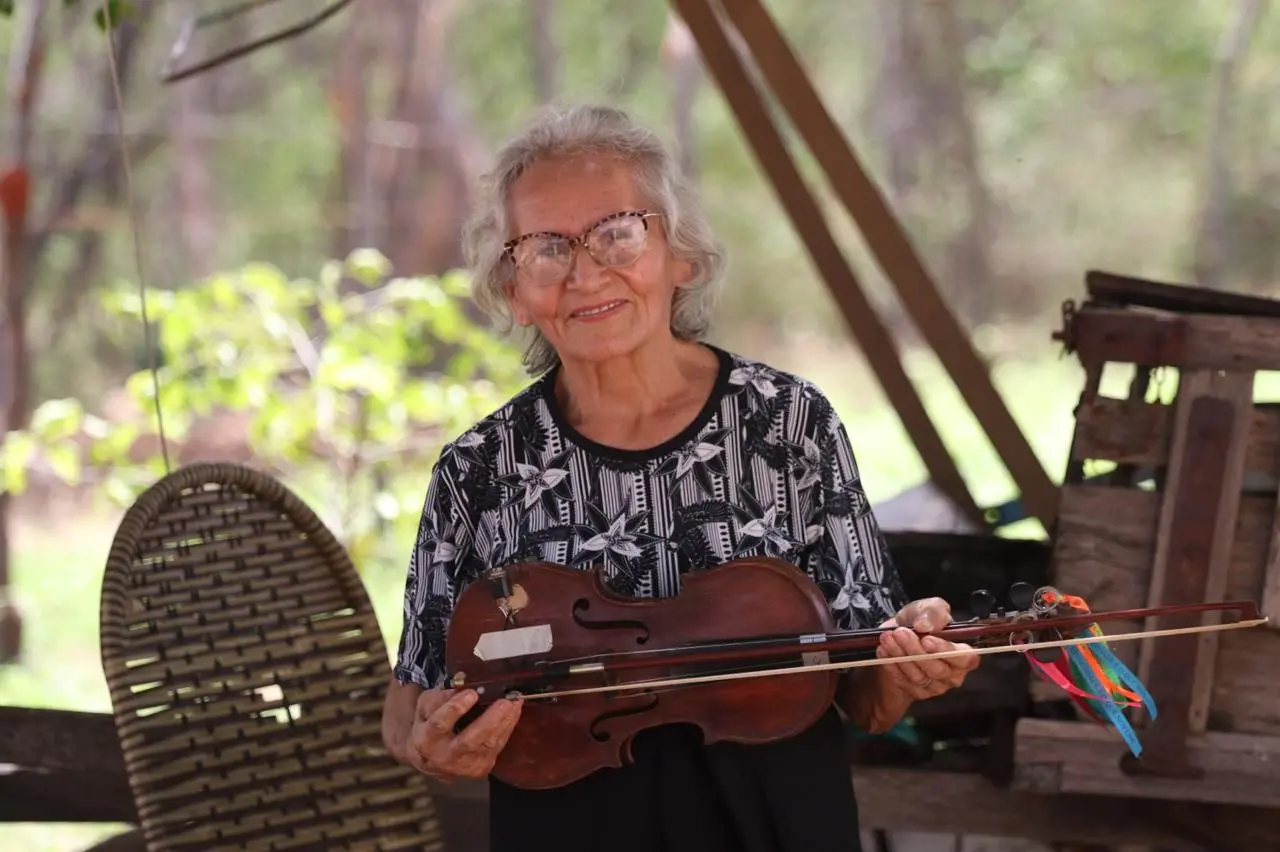 Ana Soares de Sá Oliveira, segurando uma rabeca