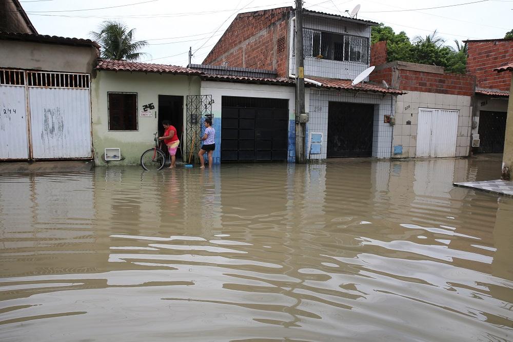 imagem de duas mulheres em área alagadas pela cheias