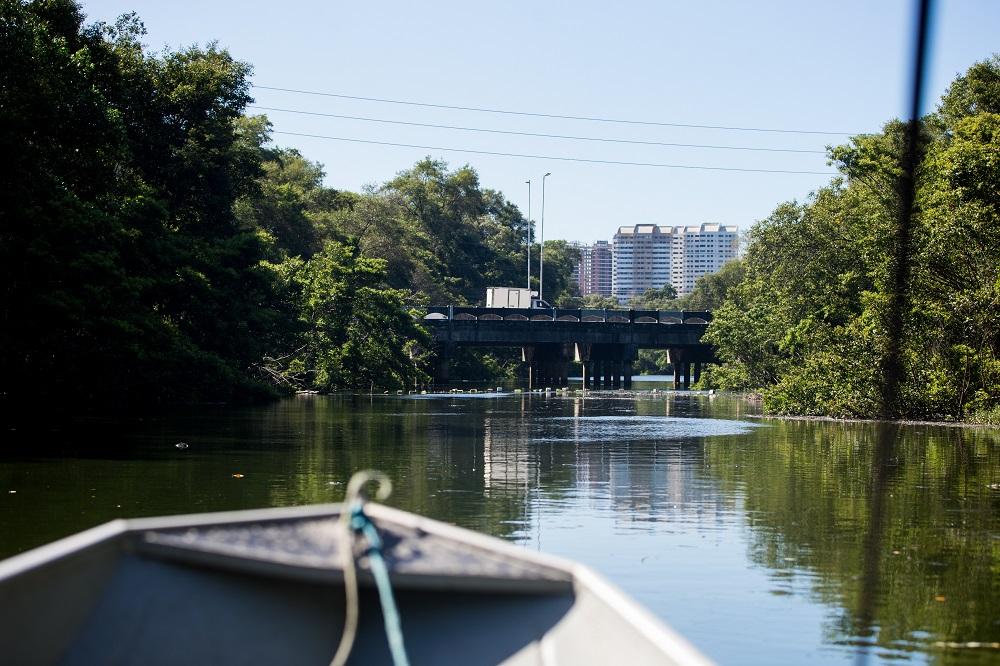 rio cocó, com o detalhe de um barco e prédio no fundo da imagem