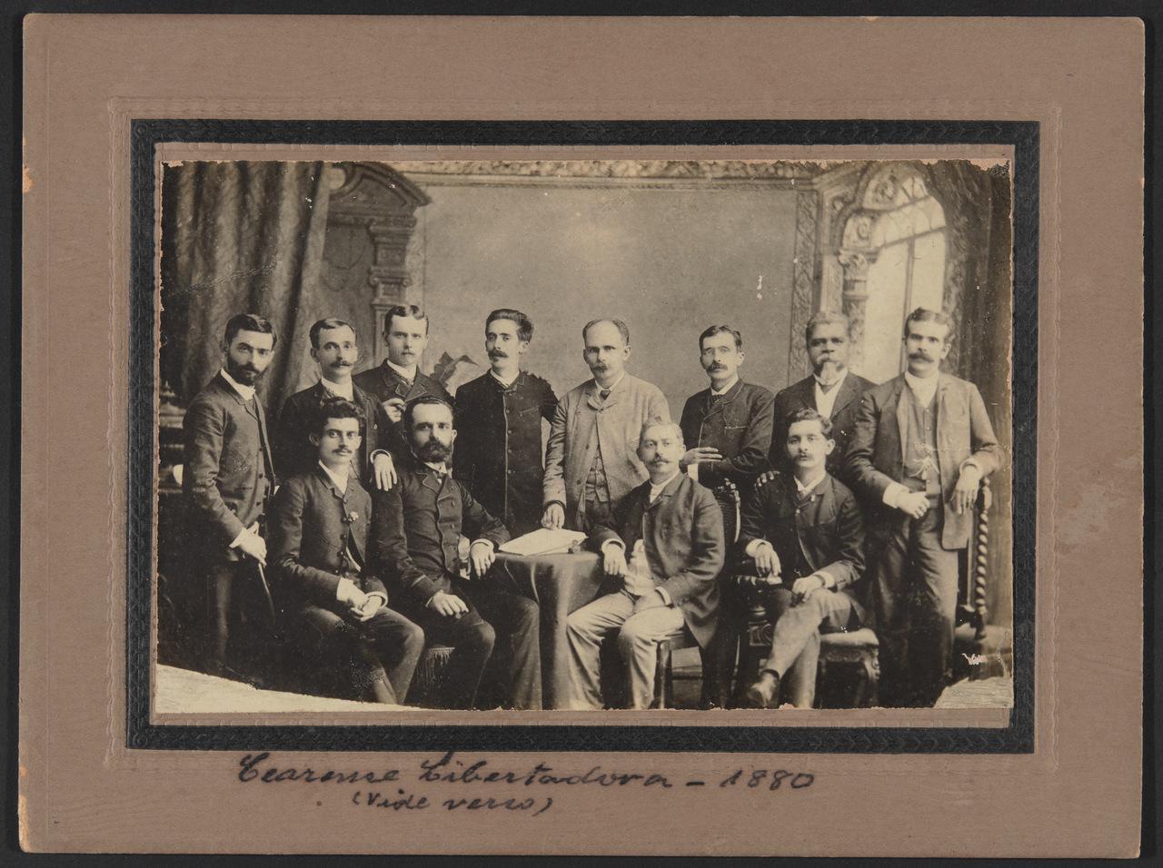 Cópia de registro fotográfico de 1880 de Chico da Matilde (o penúltimo da esquerda para direita em pé) em encontro da Sociedade Cearense Libertadora, digitalizado no MIS Ceará