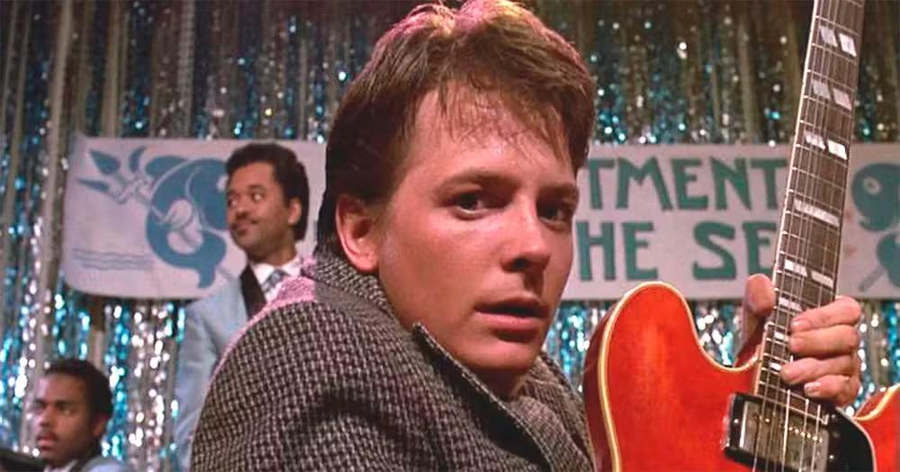 Cena do filme De volta para o futuro, em que o ator Michel J. Fox, como Marty McFly, toca guitarra