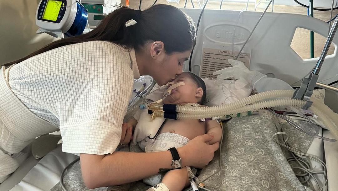 Ingra Soares beijando testa de filho Arthur, hospitalizado.