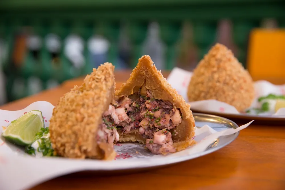 Massa da coxinha de polvo é feita com caldo de frango e recheio é um refogado temperado com alho, cebola, cheiro verde e polvo