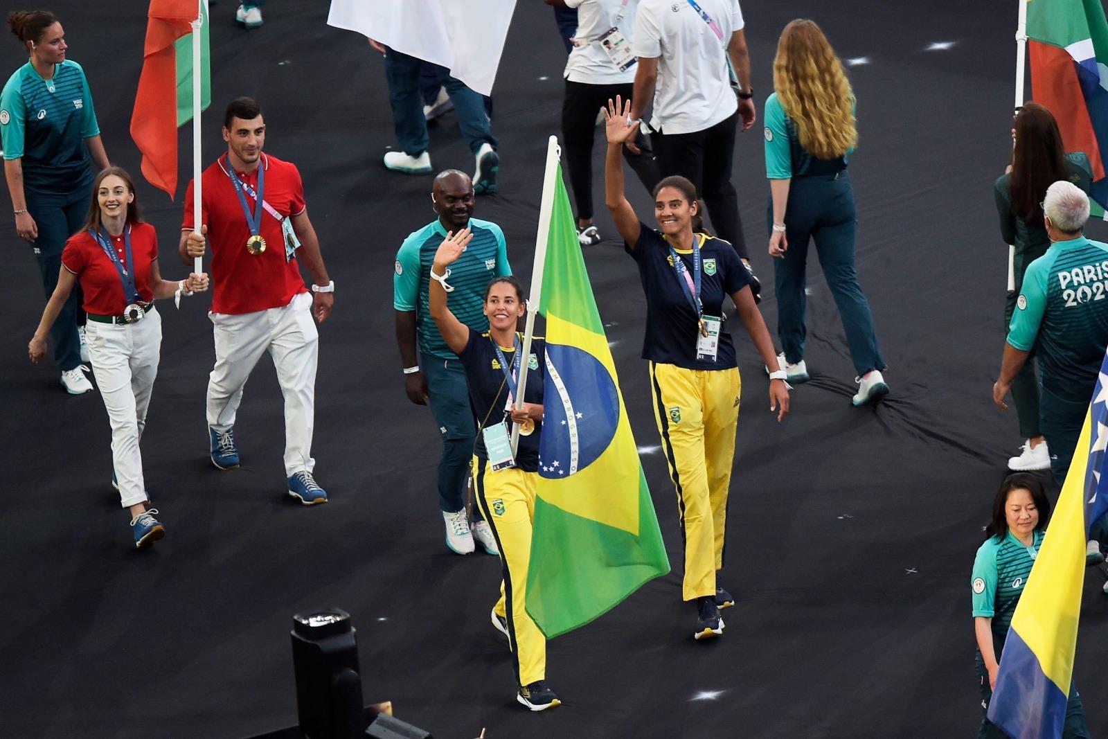 As medalhistas de ouro olímpicas no vôlei de praia Duda e Ana Patricia conduzem a bandeira do Brasil na chegada ao Stade de France para a Cerimonia de Encerramento dos Jogos Olímpicos Paris 2024