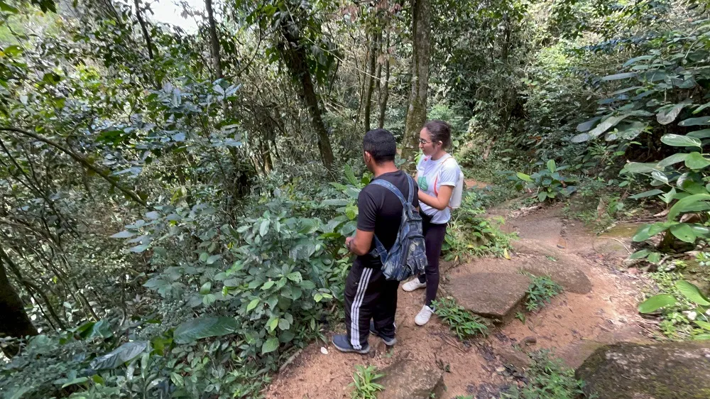 A diretora, Eduarda de Lemos, e Josué Lima, guia da equipe do documentário, encontrando o primeiro pé de café da trilha