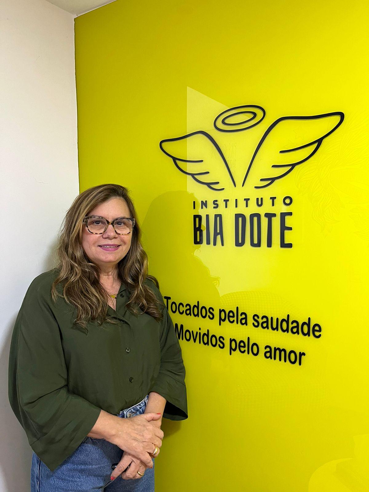 Lucinaura Diógenes posa em frente ao logo do Instituto Bia Dote