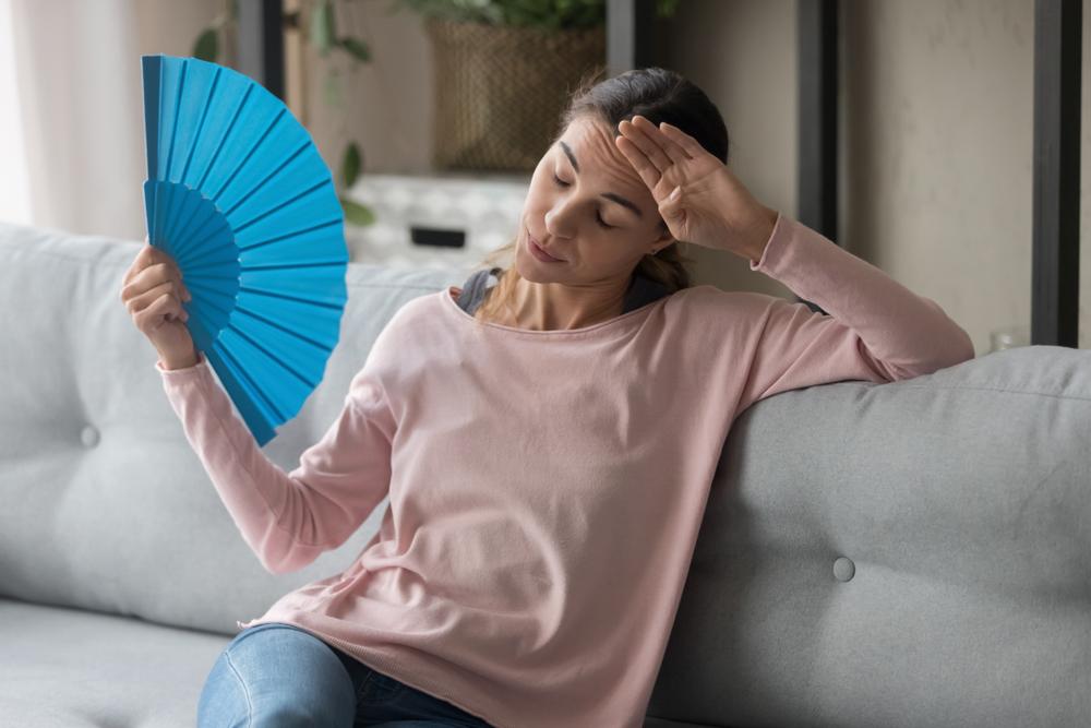 mulher se abanando durante a menopausa