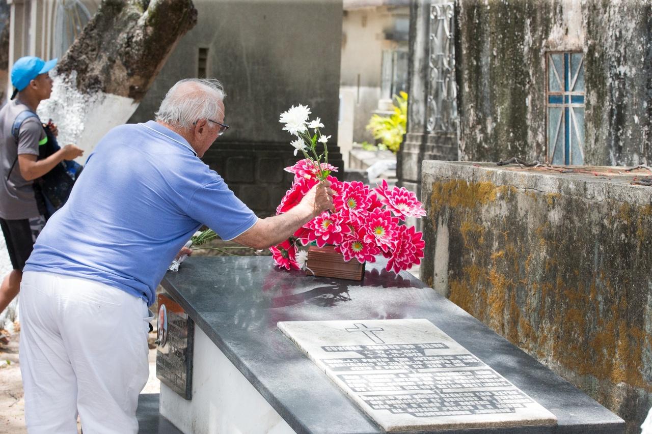 idoso deixando rosa em túmulo de cemitério em Fortaleza