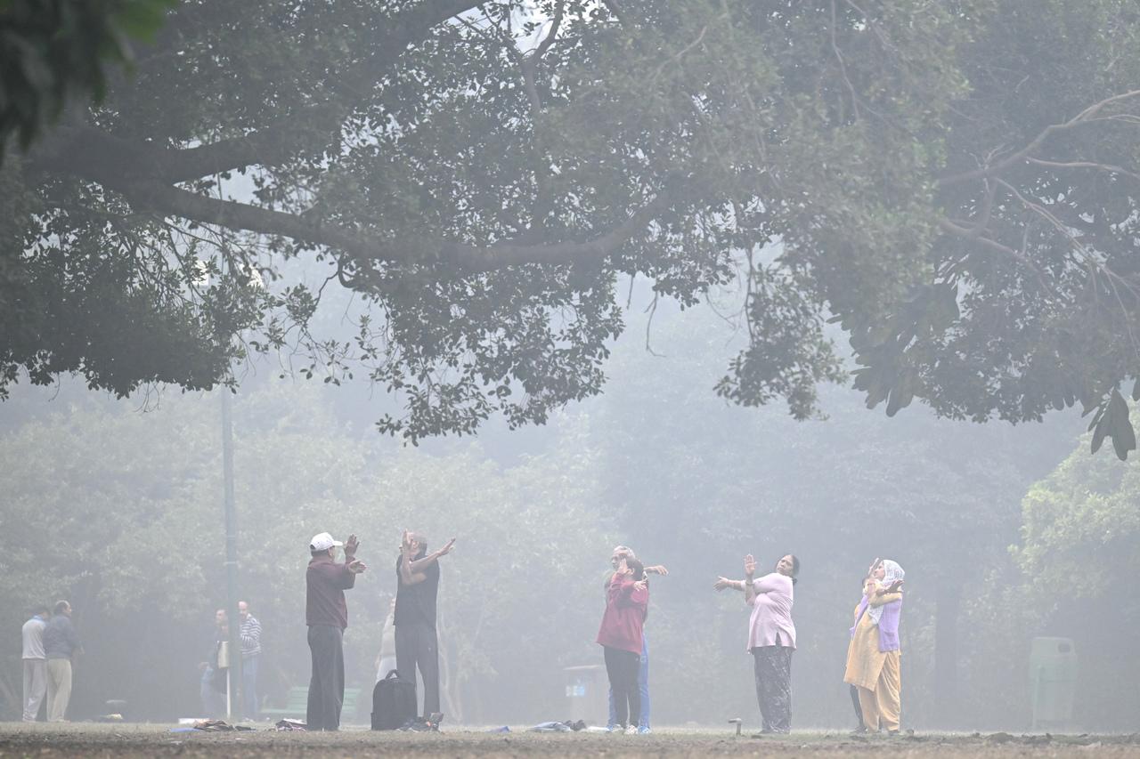 Pessoas se exercitam nos jardins de Lodhi em uma manhã fria e poluída em Nova Délhi em 18 de novembro de 2024