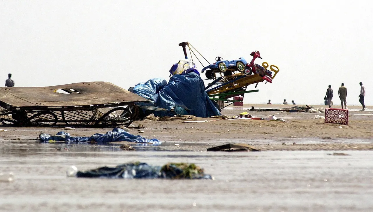 Indianos caminham entre destroços e veículos com rodas pequenas destruídos na praia de Marina, em Madras, após passagem de ondas gigantes
